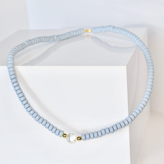 Light blue beaded necklace on a white background